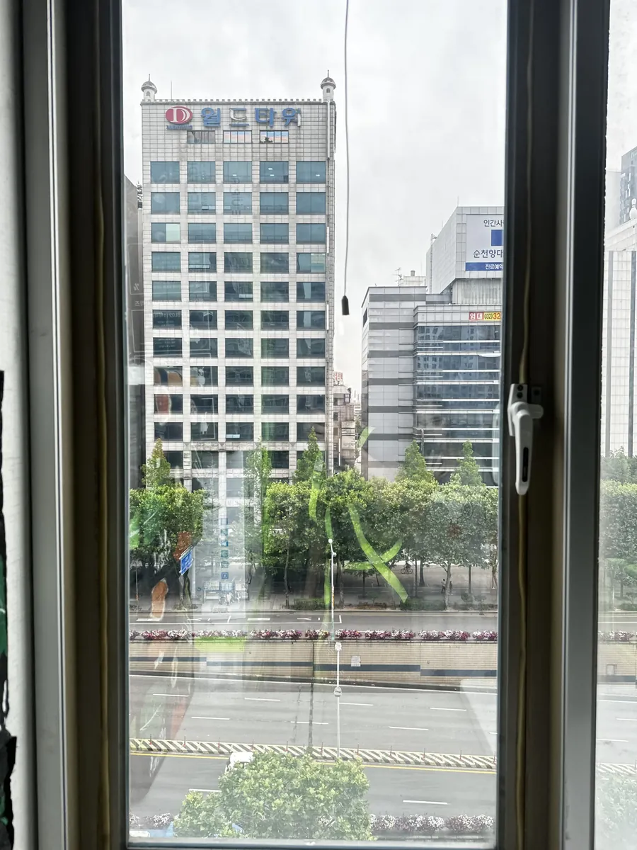 도심이 보이는 캐시먼트 창문을 옆에서 확인하며 개폐 저항을 점검하는 모습