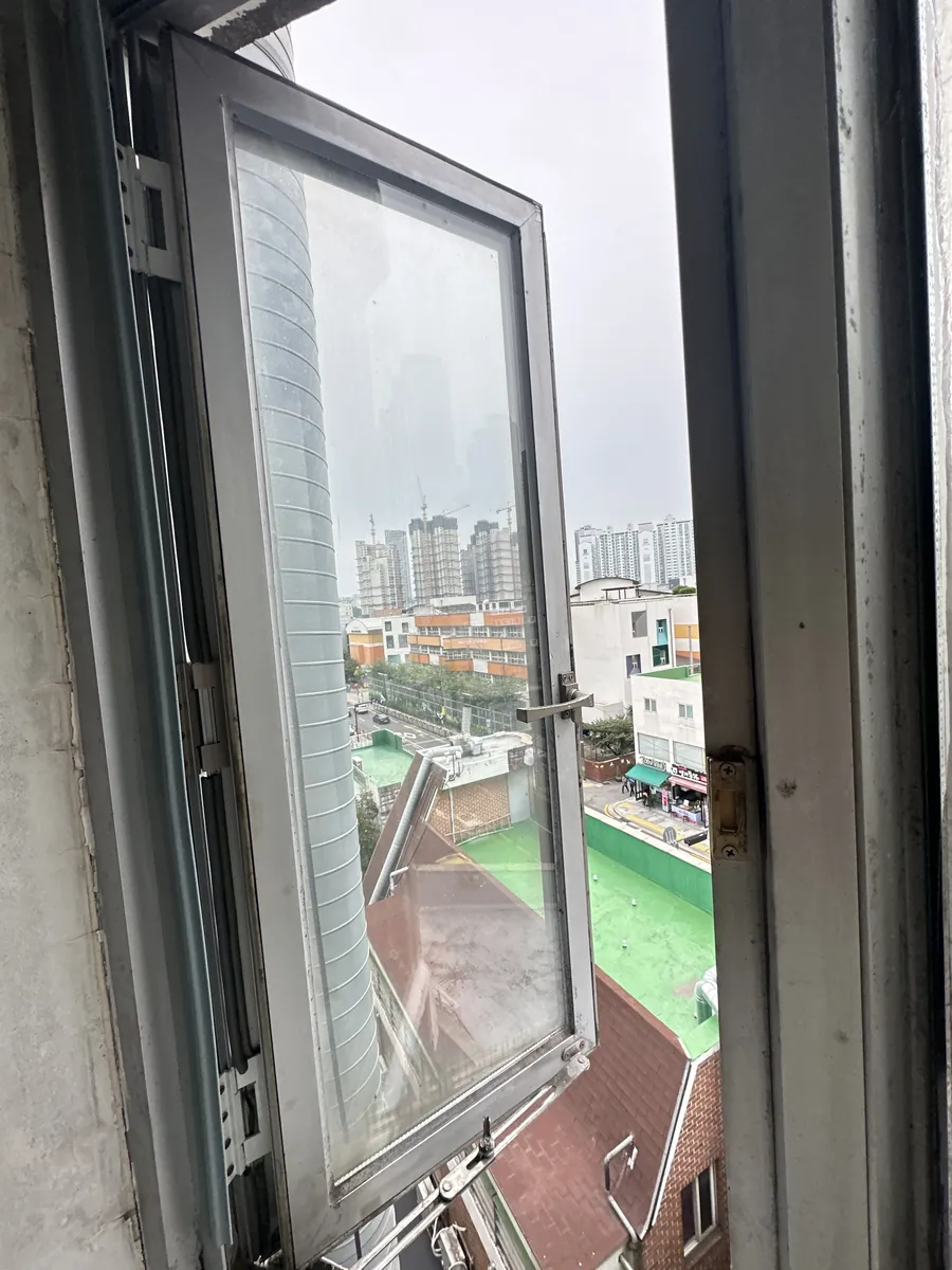 오피스텔 창문 캐시먼트 창짝을 열어 실리콘 접합부 점검하는 모습