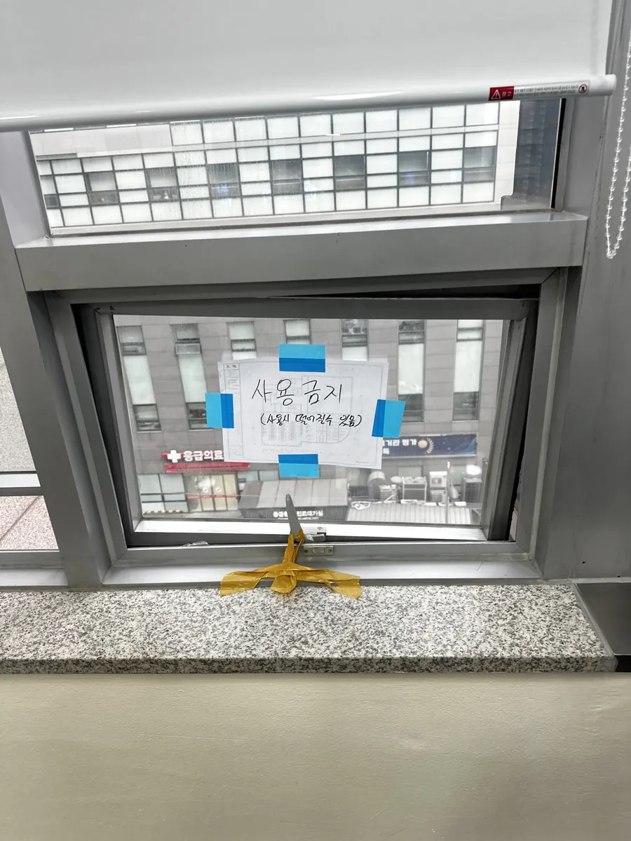 사용금지 안내문과 테이프로 손잡이를 임시 고정해 둔 위험한 프로젝트 창문