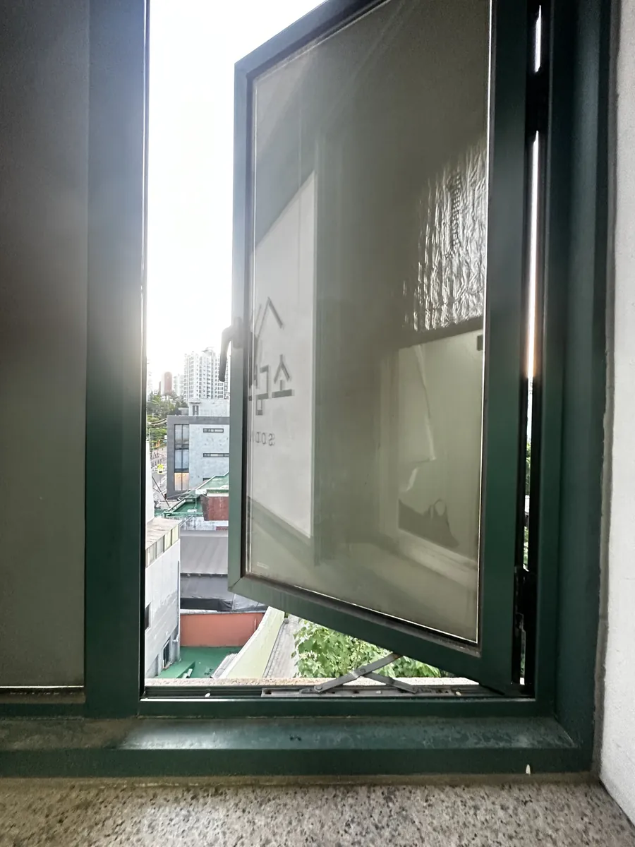 빌딩 창호 경첩과 하단 스테이 브라켓이 함께 보이는 개폐 구조 확인 사진