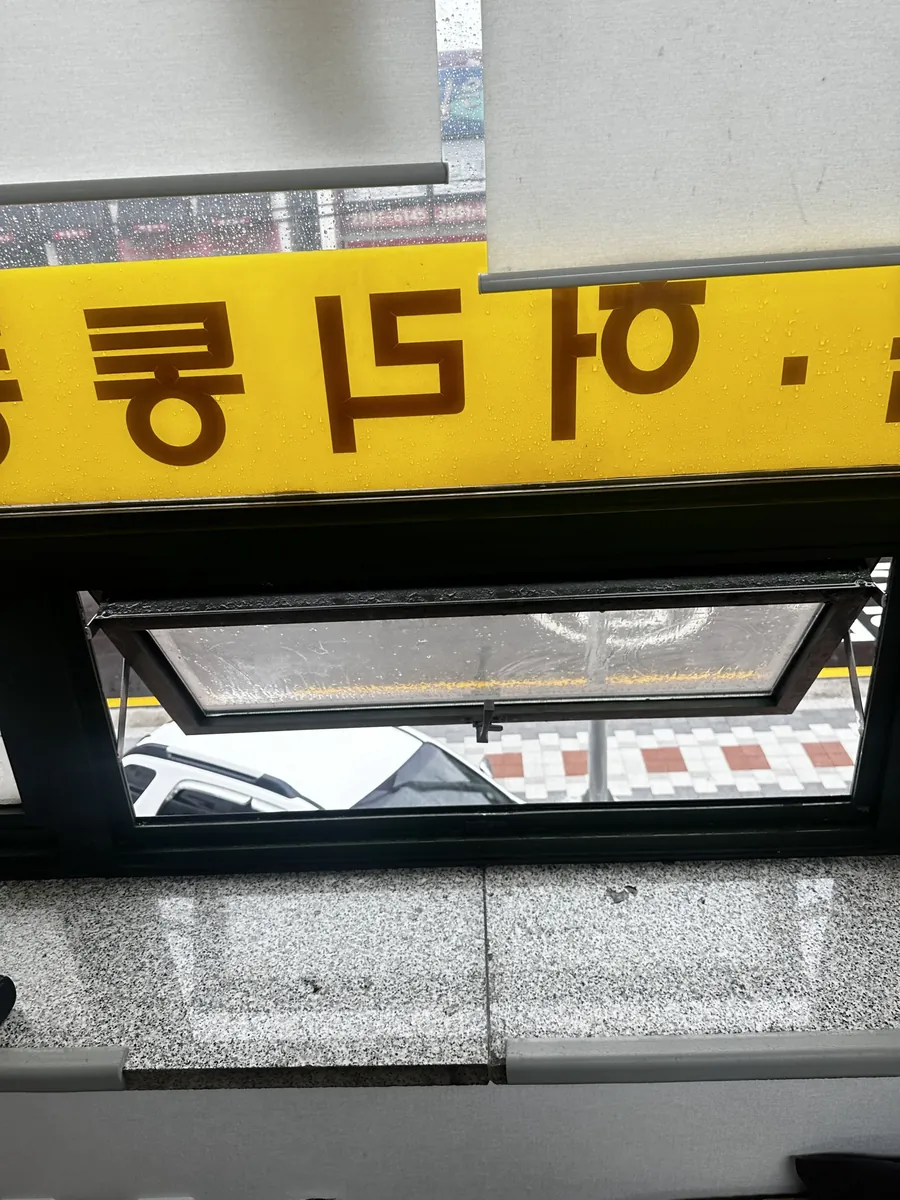 작은 환기창이 살짝 젖혀진 상태로 열려 있는 프로젝트 창문